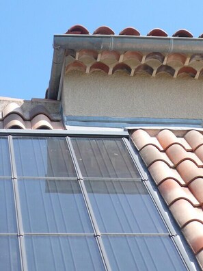 A building with a flat roof, large windows, and terracotta tiles.