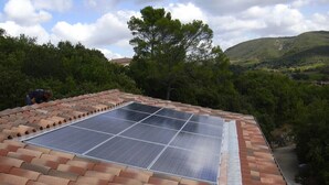Una azotea con paneles solares y tejas de barro.