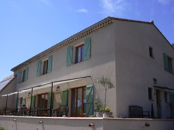 A two-story building with a balcony and outdoor seating area.