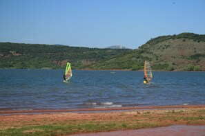 A lake with two windsurfers.