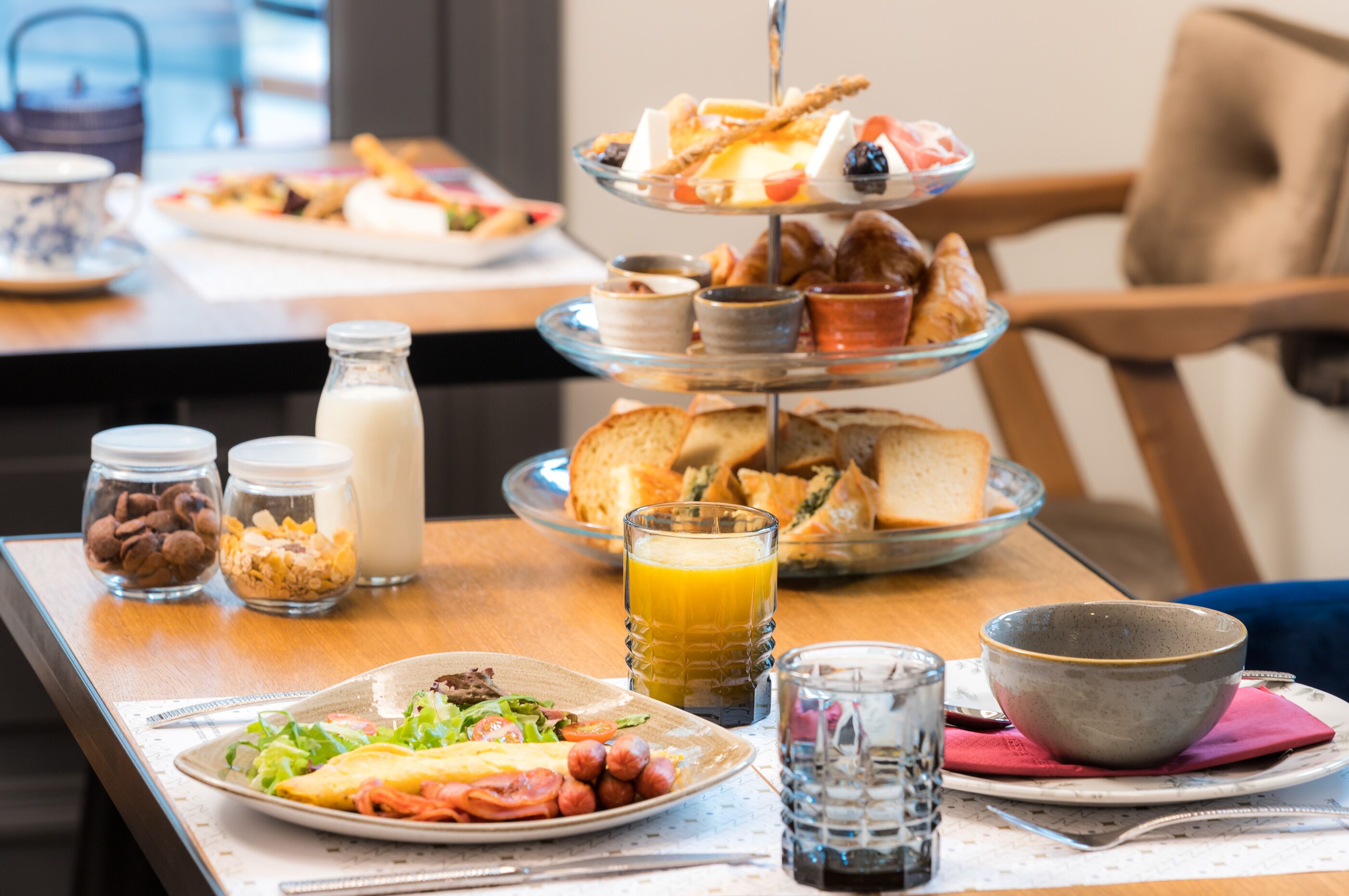 Een ontbijtbuffet met diverse etenswaren en drankjes op een houten tafel.