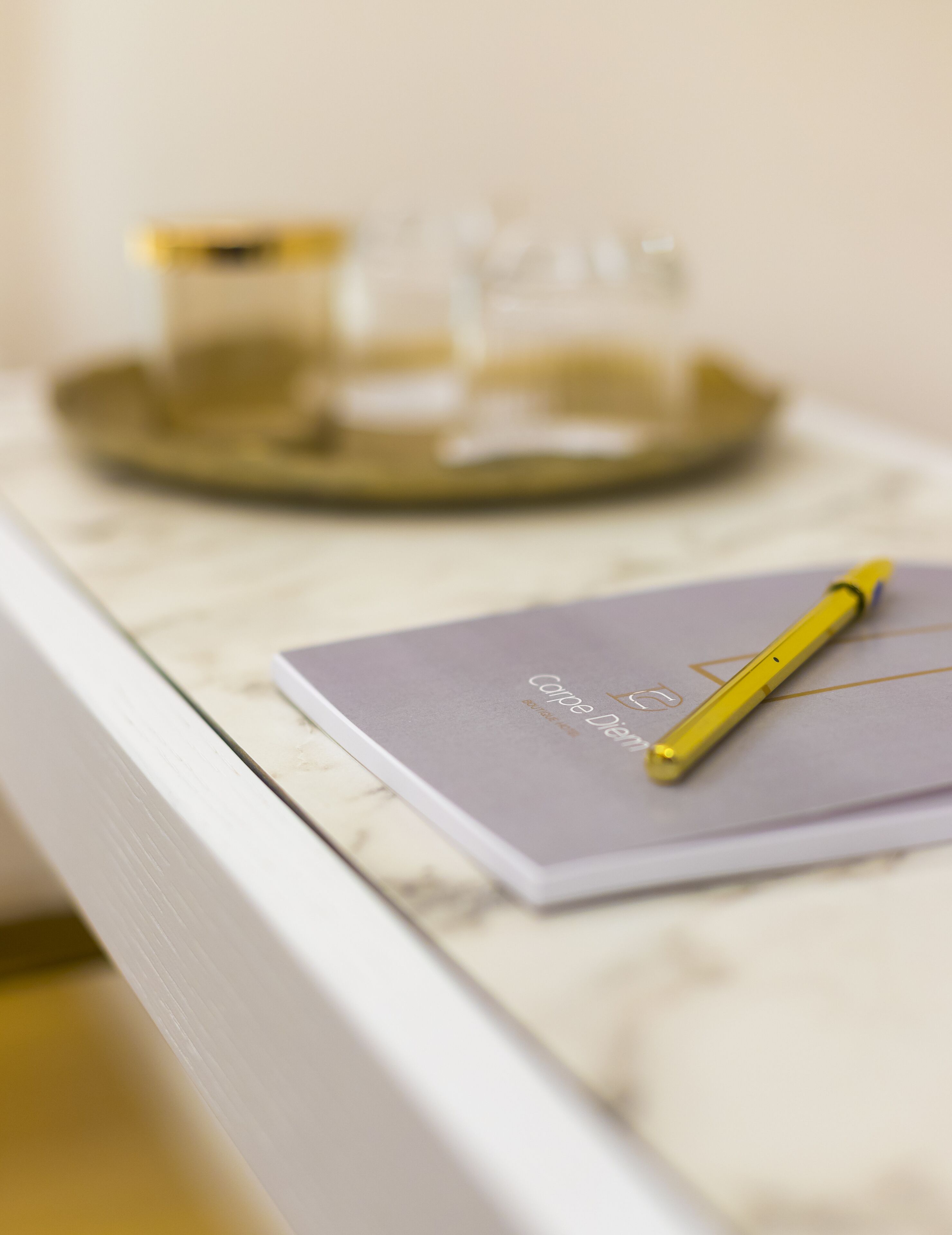 Un carnet et un stylo posés sur une surface en marbre.
