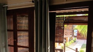 A room with a wooden door and a view of an outdoor deck. - La Case Bois Creole (COCO) (Albion)