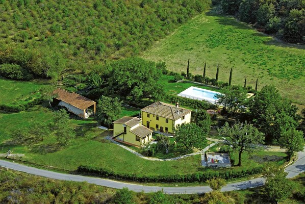 An aerial view of a rural property with a large house, a swimming pool, and surrounding greenery. - Villa del Poggetto (Terranuova Bracciolini)