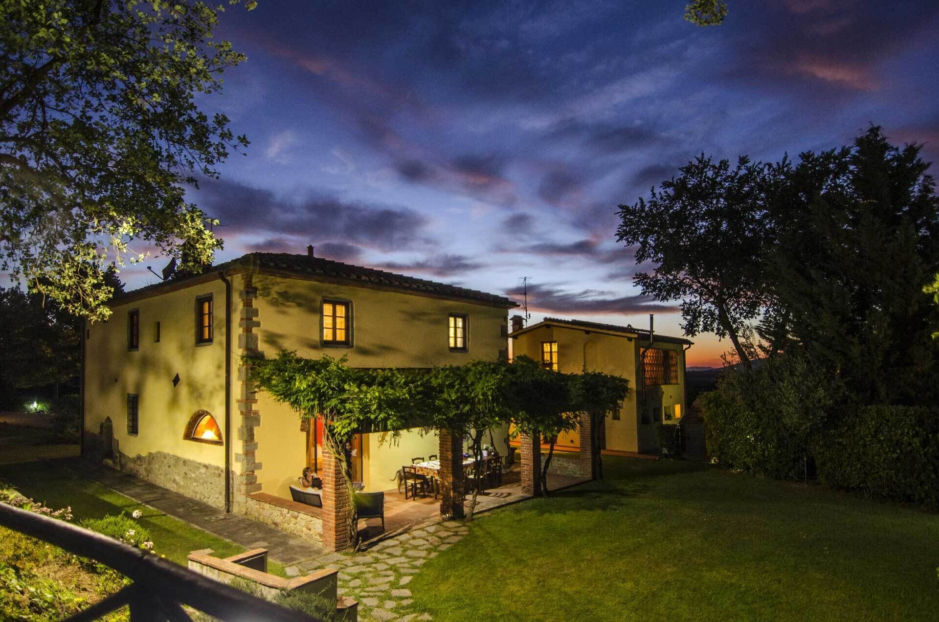 Vista frontal de la propiedad por la tarde o noche