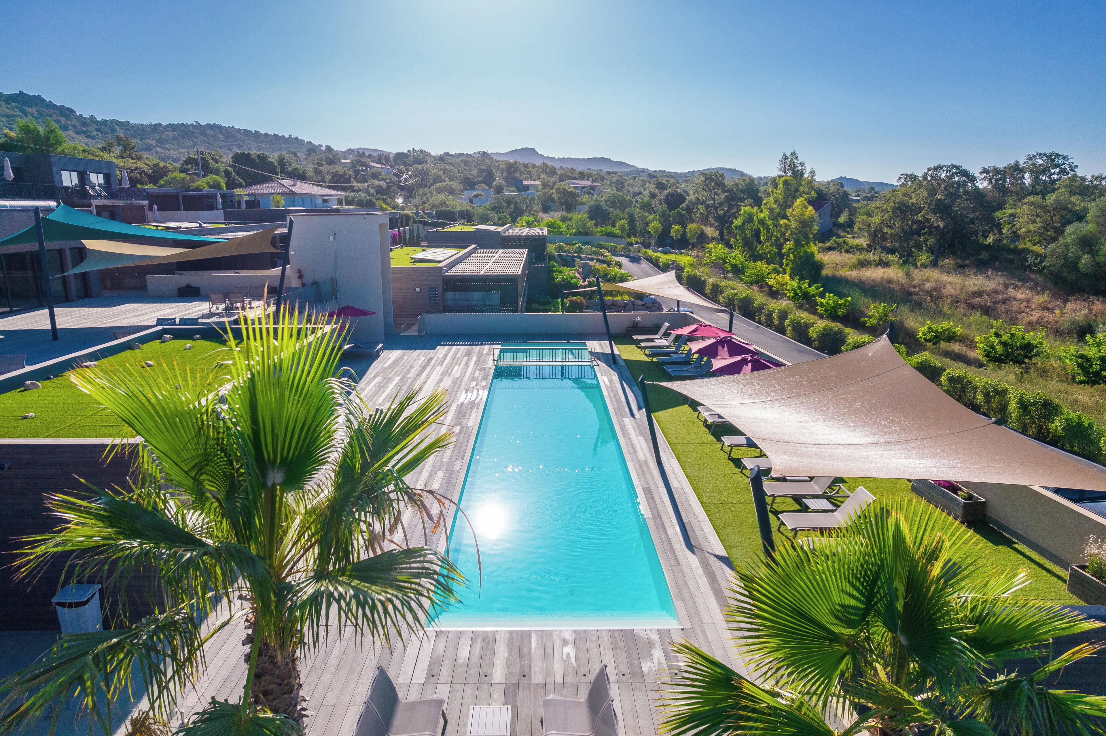 Een seizoensgebonden buitenzwembad en ligstoelen