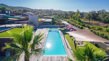 Een seizoensgebonden buitenzwembad en ligstoelen