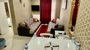 A modern living room with a sofa set, a dining table with chairs, and a large mirror. - Beyaz Suites & Hotel (Istanbul)