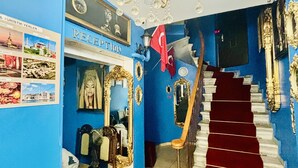 A reception area with a blue wall, a chandelier, a staircase with a red carpet, and a flag. - Beyaz Suites & Hotel (Istanbul)