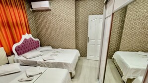 A hotel room with two beds, a mirror, a wardrobe, and patterned wallpaper. - Beyaz Suites & Hotel (Istanbul)