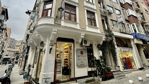 A multi-story building with a prominent entrance, a sign for 'ERTEKS Group Tentsim A.S.', and a storefront named 'ERVA'. - Beyaz Suites & Hotel (Istanbul)