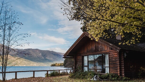 A wooden cabin by a lake with a clear view of mountains in the background. - Beatiful Cabin in Bariloche (San Carlos de Bariloche)