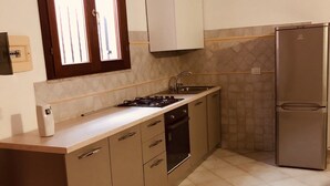 A kitchen with a stove, sink, and refrigerator. - Fantastico Budoni Tauanella ARGO02 (Budoni)