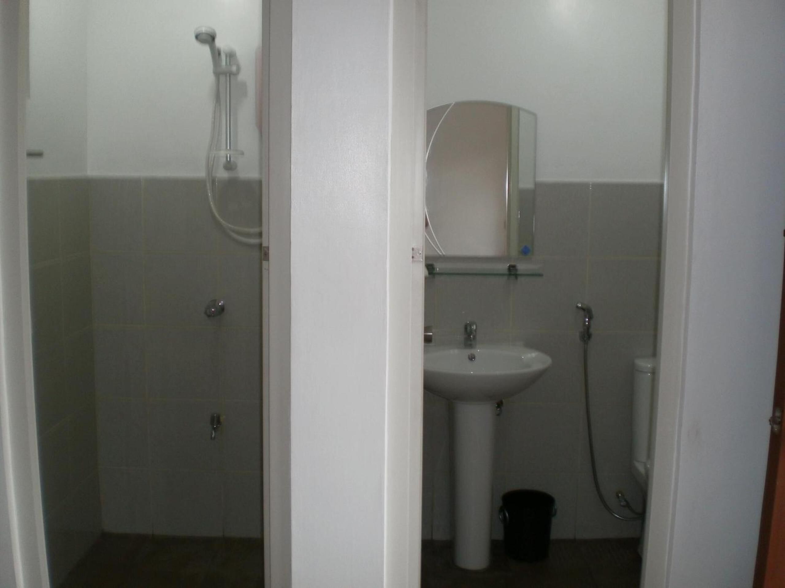 A bathroom with a shower, sink, and mirror.