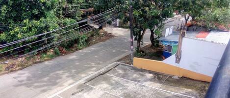 A concrete pathway leading to a building with a white and yellow facade.