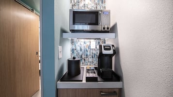 A kitchenette with a microwave, coffee maker, and a small refrigerator.