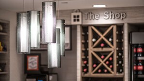 Una cava de vinos con una estantería y un letrero que dice "The Shop".