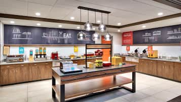 Un espace buffet pour le petit-déjeuner proposant une grande variété de plats, un menu écrit à la craie et un design moderne.
