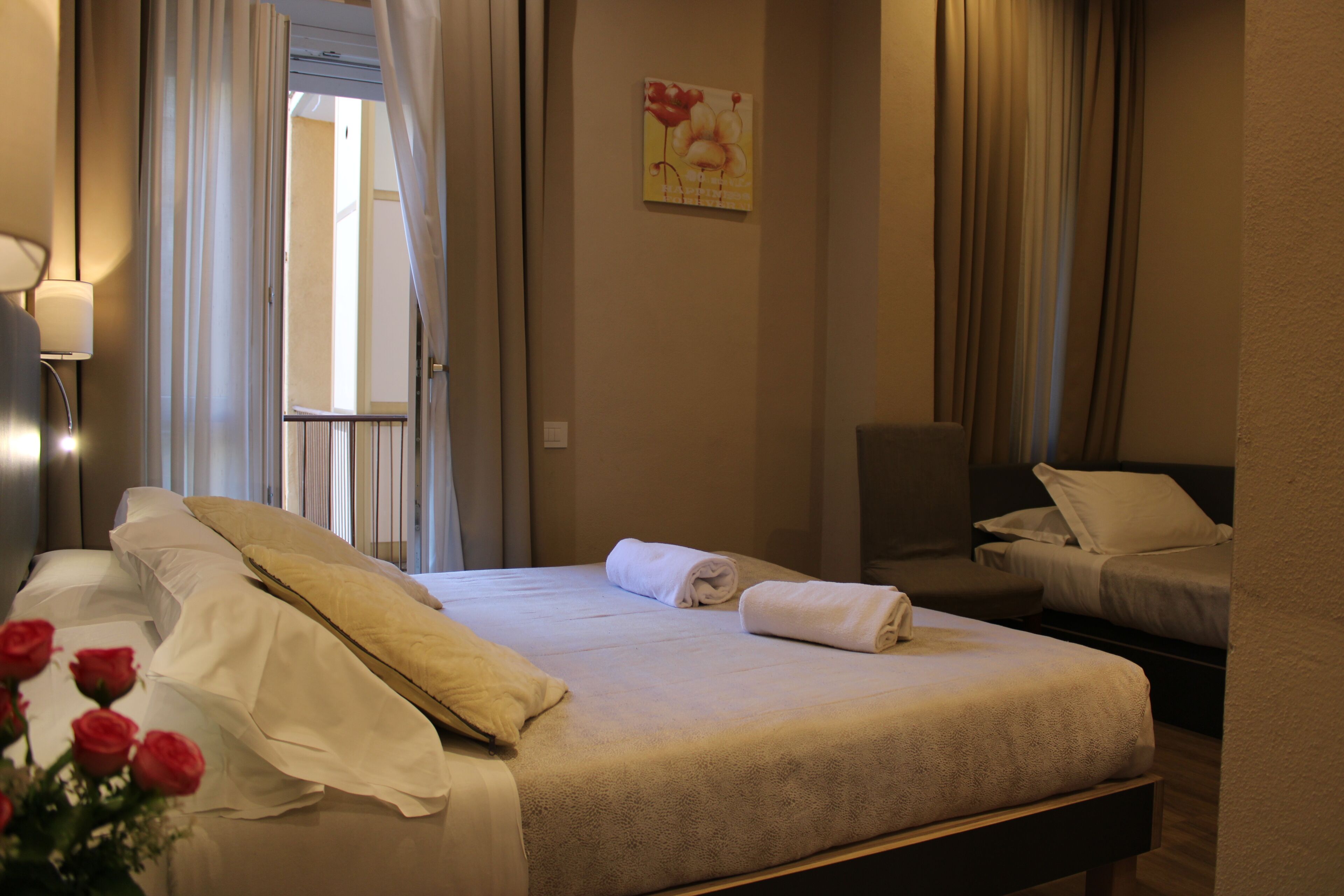Ein Hotelzimmer mit Bett, Sessel und einem Bild an der Wand.
