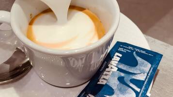 A cup of coffee with milk being poured into it.