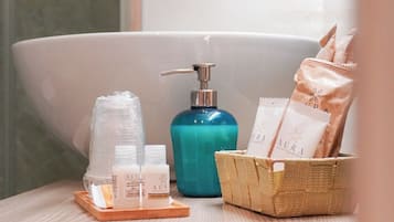 Une salle de bain avec une baignoire, un distributeur de savon et des articles de toilette rangés dans un panier.