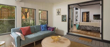 A modern living room with a sofa, a round coffee table, and a large window.