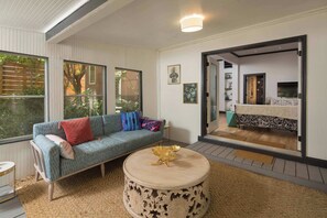 A modern living room with a sofa, a round coffee table, and a large window.