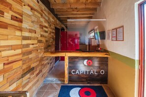 A wooden reception desk with a logo, a red locker, and a blue mat with a circular design. - Pozo Viejo (Zacapoaxtla)