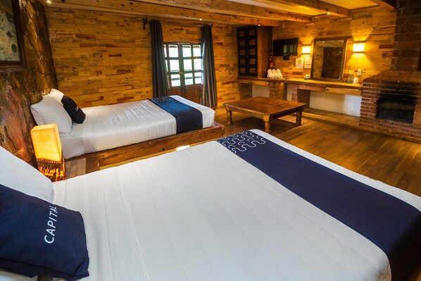 Una habitación de estilo cabaña de madera con dos camas, una mesa de madera y una chimenea.