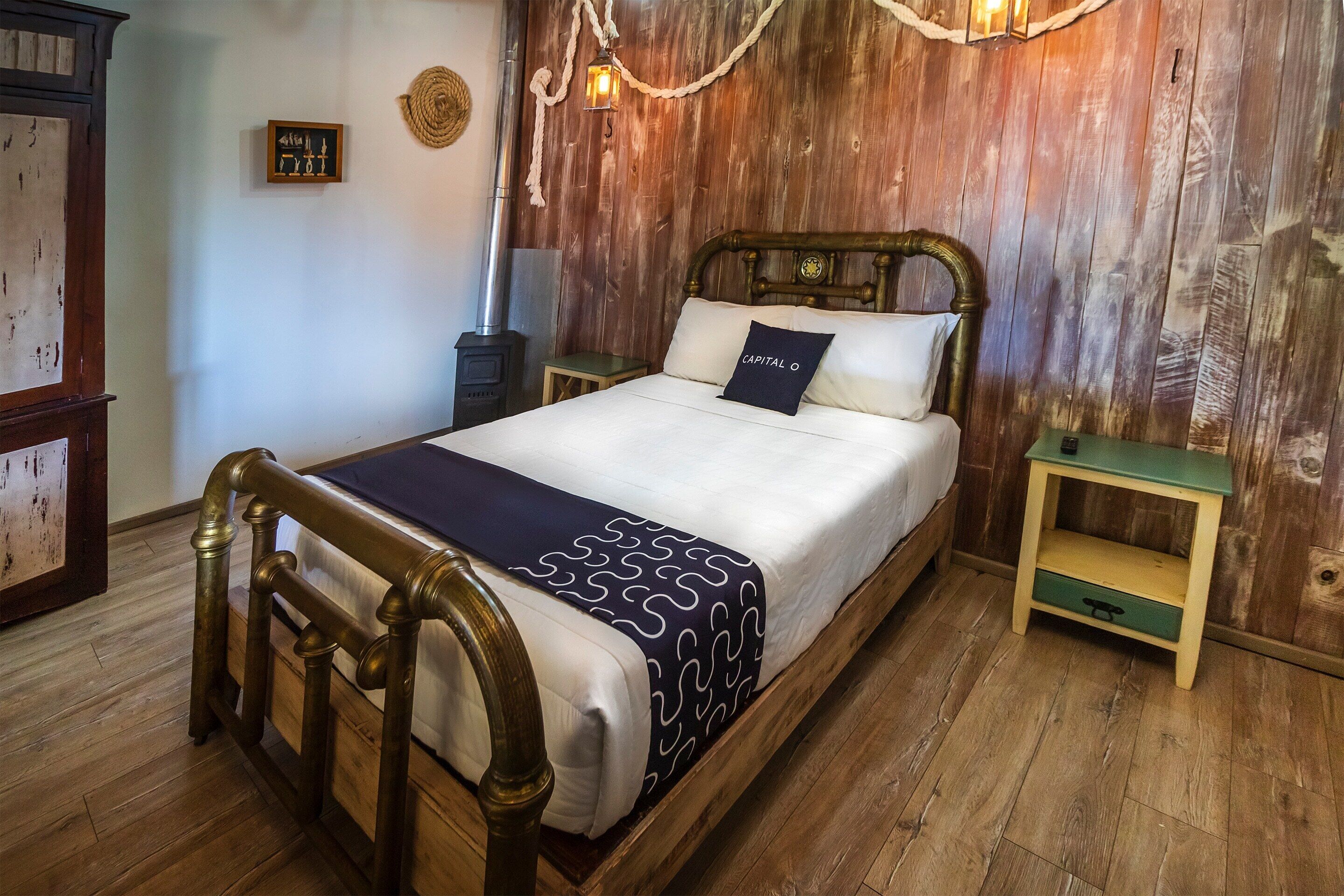 A wooden bed with a headboard, a bedside table, and a nightstand.