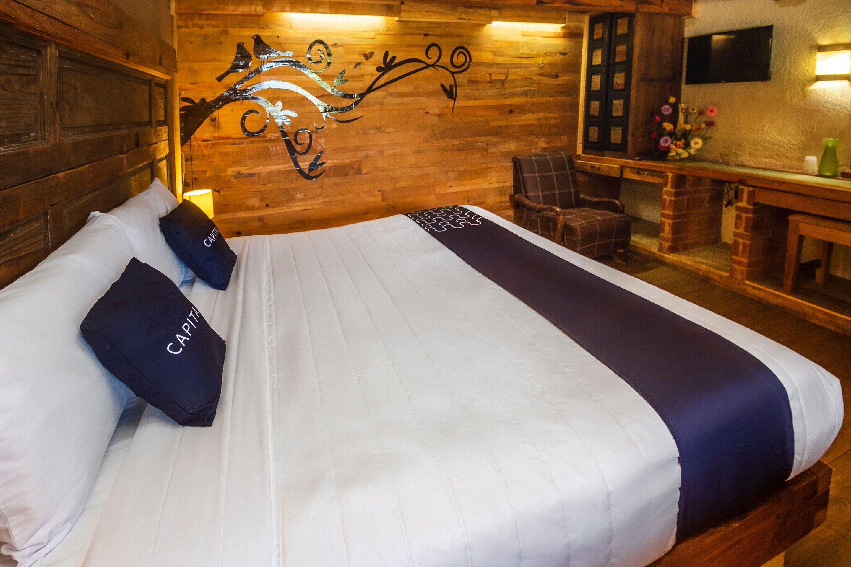 Una habitación tipo cabaña de madera con una cama grande, un escritorio y una silla.