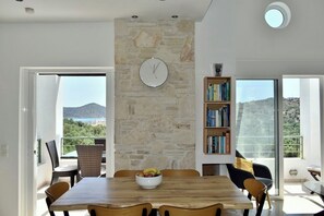 Un coin repas avec un mur en pierre, une horloge et une bibliothèque.