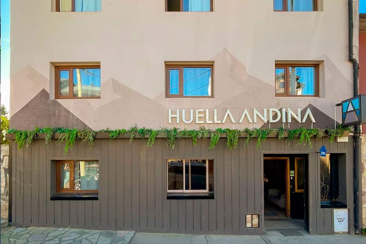 Ett hotell med flera våningar och modern design, med en framträdande skylt som visar texten "HUELLA ANDINA".