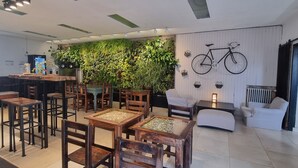 Ein modernes Interieur mit Holzmöbeln, einer grünen Wand mit Pflanzen und einem an der Wand befestigten Fahrrad.