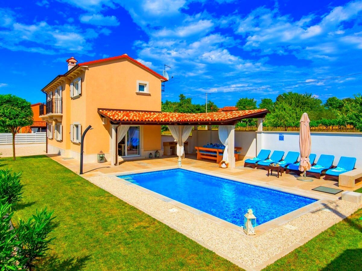 Una casa a due piani con piscina, veranda coperta e giardino.