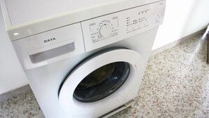 Een voorzicht vanuit een witte wasmachine, met bedieningspaneel en een klep aan de voorkant.