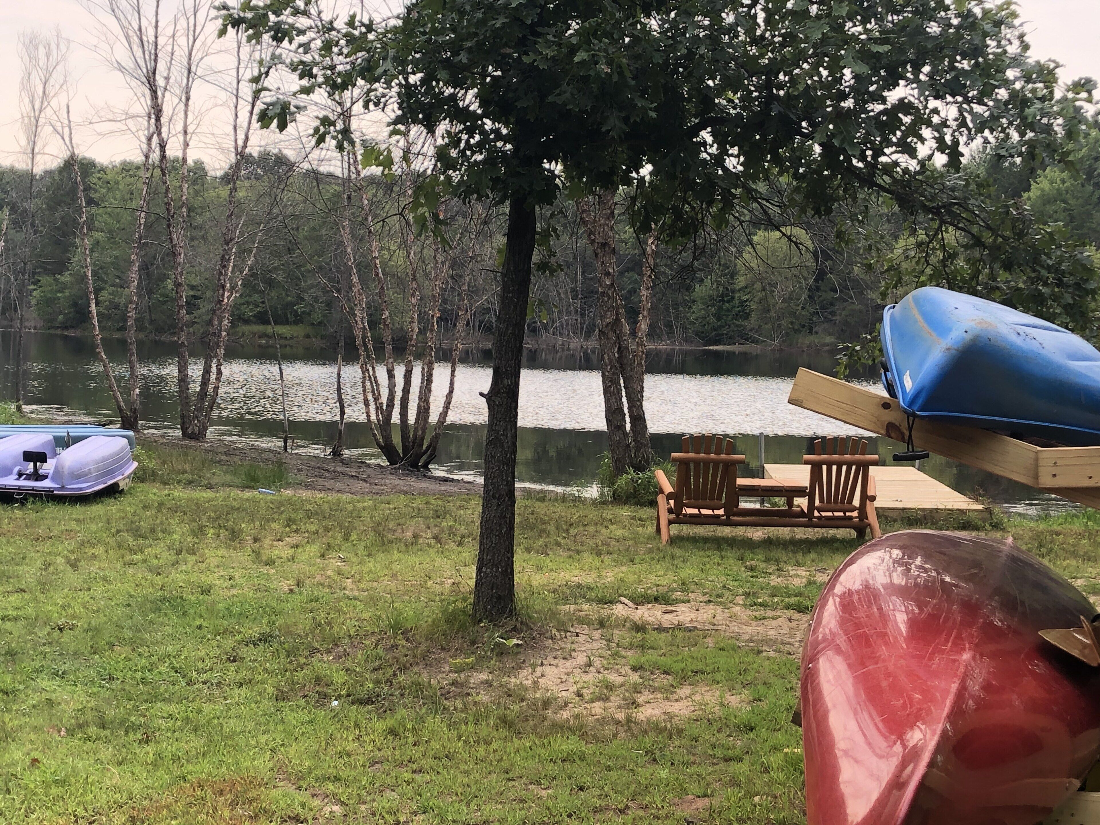Paisatge amb un llac, una barca, un cànoi i una taula de paddle.