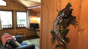 A wooden interior with a sofa, a television, and a decorative wall piece. - Snowdrop 14 Hot Tub (Carmarthen)