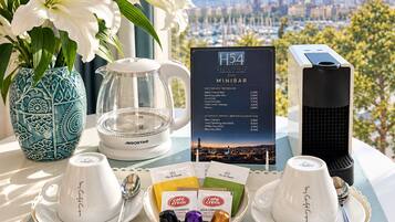 Una preparación para el desayuno con un menú, tazas de café, un calentador de té y un florero decorativo.