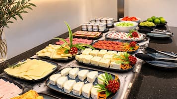 A buffet table with various food items and utensils.