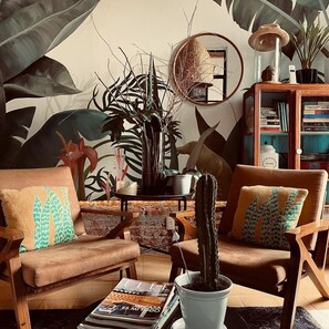 Relax in this inviting living room with a comfortable sofa, coffee table, and lush greenery.
