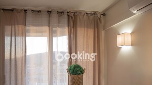 Una habitación con una mesa, sillas, una planta en maceta y una lámpara de pared.