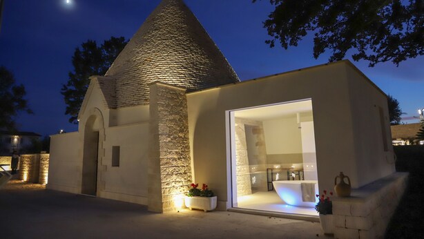 A building with a stone tower and a modern glass entrance. - TD Trullo Roverella Charming Trullo with Pool (Castellana Grotte)