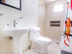 A bathroom with a white sink, toilet, and shower. - Suites del Pozo (San Luis Potosi)