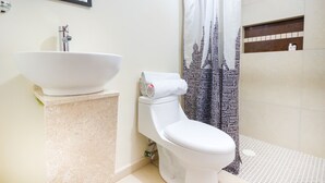 A bathroom with a white sink, toilet, and shower curtain with a cityscape print. - Suites del Pozo (San Luis Potosi)
