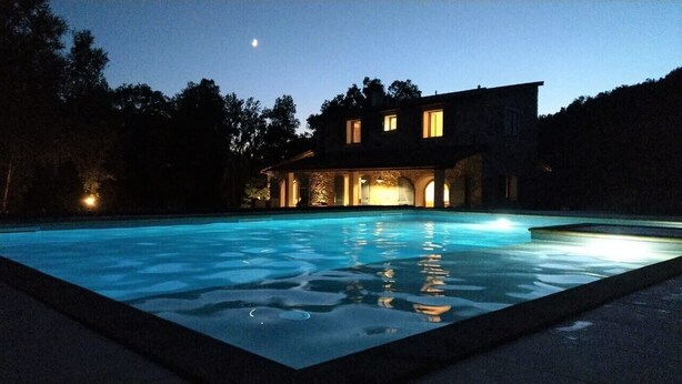 A swimming pool with a house in the background. - Fantastic new villa near the sea in one of the most beautiful areas of Tuscany  (Pomaia)
