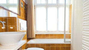 A bathroom with a white sink, toilet, and bathtub. - Lille Villa App Moon Westerland (Westerland)