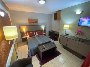 Escritorio, cortinas blackout y tabla de planchar con plancha