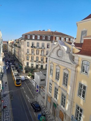 Vista callejera con un tranvía, edificios de arquitectura clásica y cielo despejado.