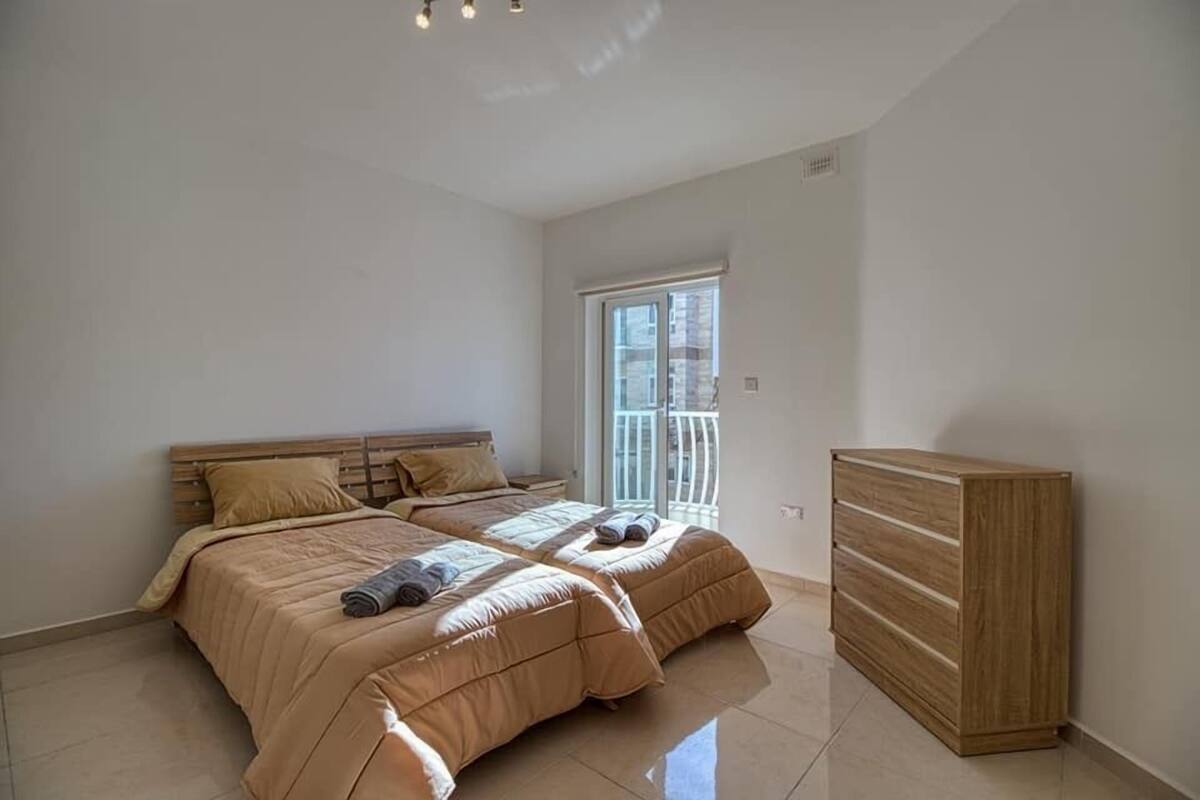 Ein Schlafzimmer mit einem Bett, einem Holzschrank und einem Fenster mit Blick.
